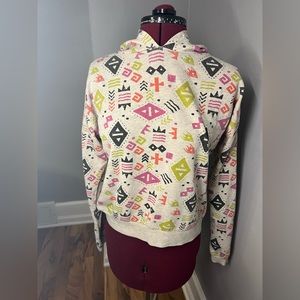 Spaceship Trippy designed pull over hoodie, multi designs, beige and is a small